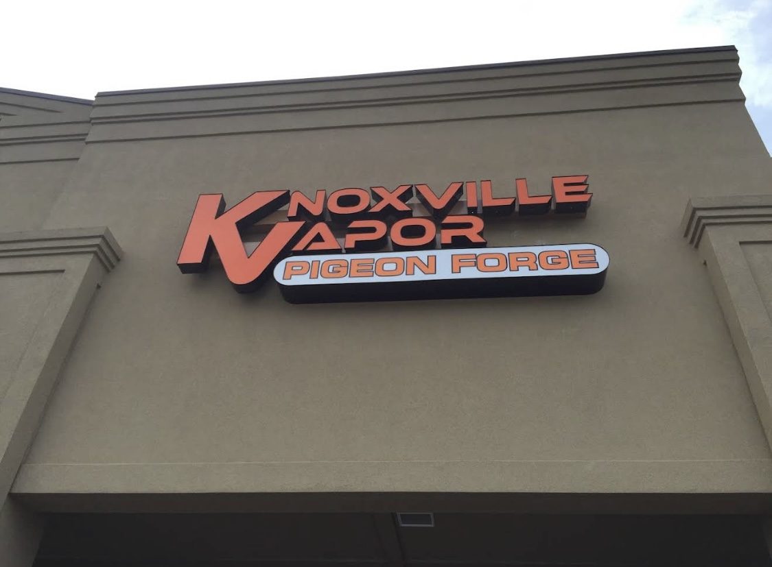The orange Knoxville Vapor Pigeon Forge sign on the shop front
